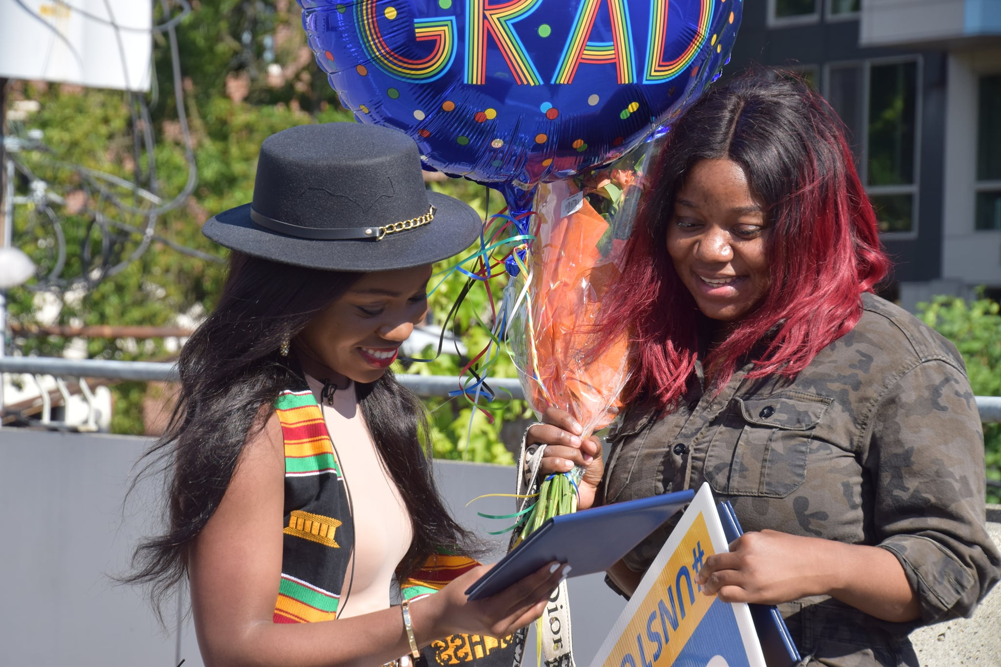 Two sisters compare graduation notes on their graduation day