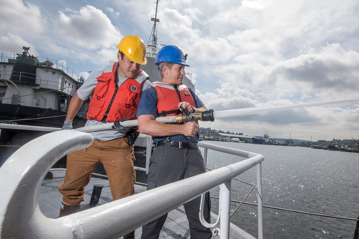 Seattle Maritime students on a boat with a firehose