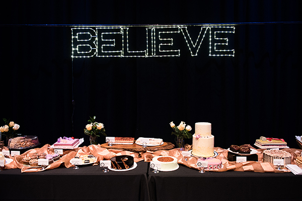 a lighted sign of Believe displays above the dessert dash table