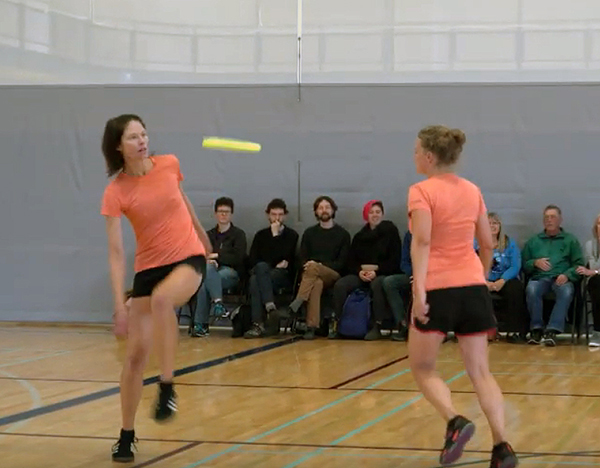 two female frisbee athletes perform a rouitine