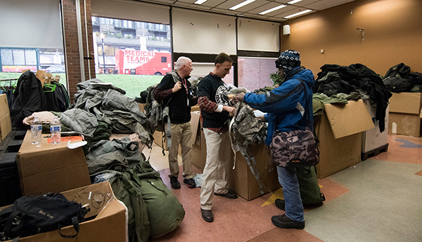 volunteers help a homeless man during a service event