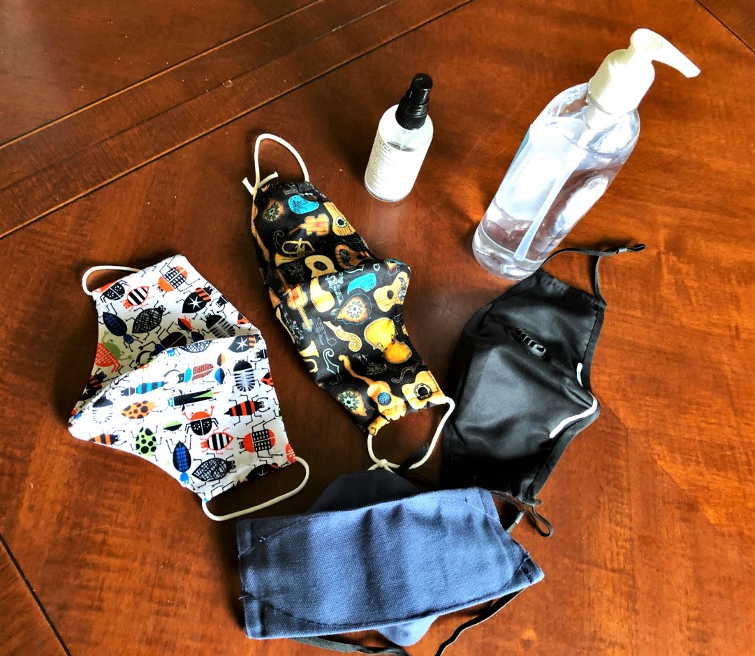 an array of face coverings and disinfectants on a table