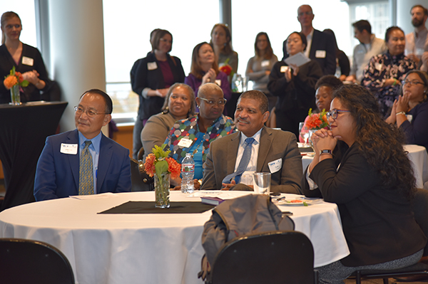 Chancellor Shouan Pan, Year Up President Cyril Turner, and South Seattle President Rosie Rimando-Chareunsap listen to a student speaker